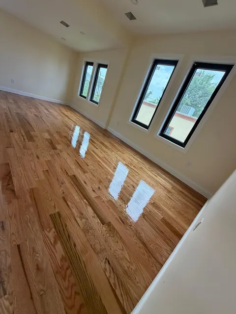 Bedroom with refinished red oak floor and black window frames