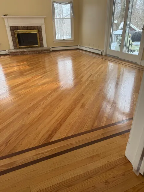 Living room oak floor with dark inlay border and fireplace