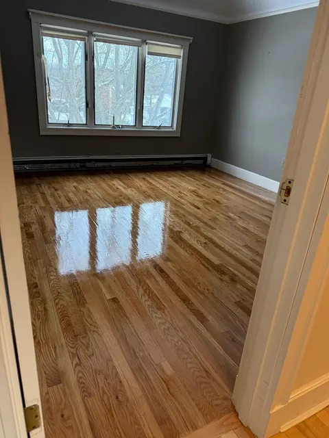 Oak floor refinished with glossy finish in a room with dark gray walls