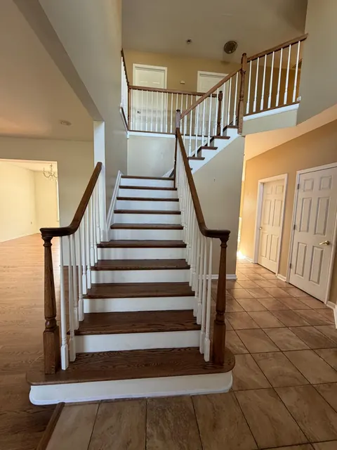 Foyer staircase with refinished oak treads and white balusters