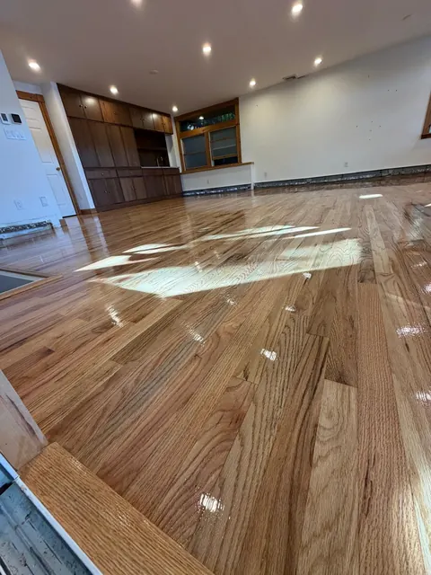 Open kitchen and living area with a glossy refinished oak floor