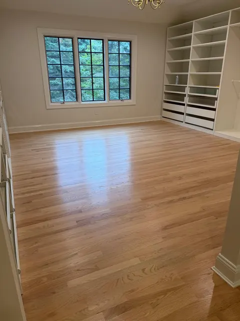 Room with built-in shelves and a natural white oak floor