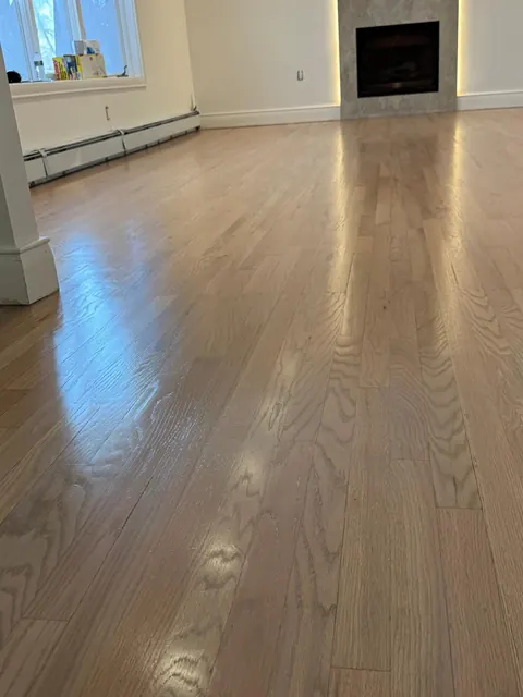Living room with a fireplace and a refinished oak floor in a light natural finish