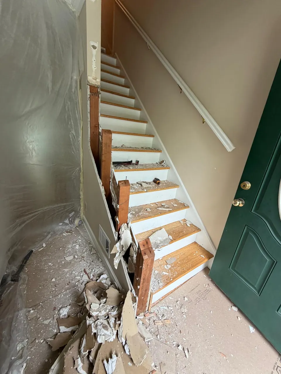 Before: staircase with damaged treads next to a front door