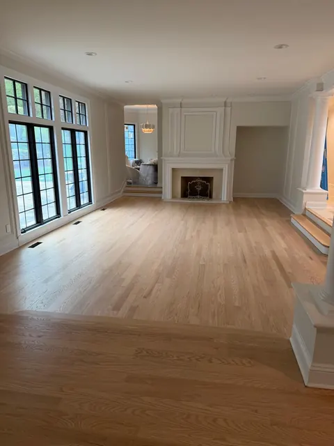 Open living room with fireplace and newly refinished light oak floor
