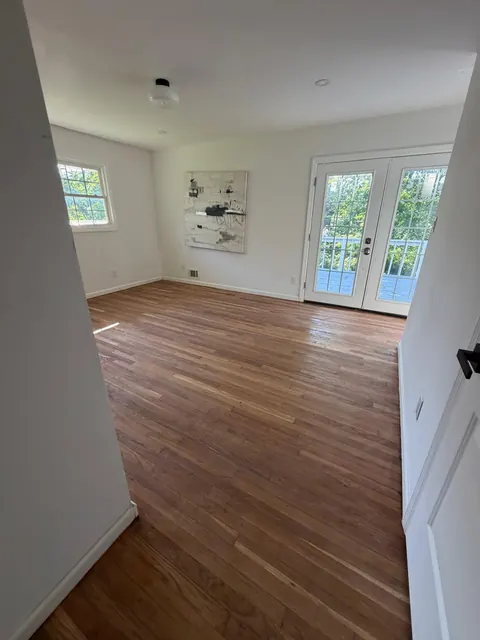 Refinished oak floor in a room with French doors