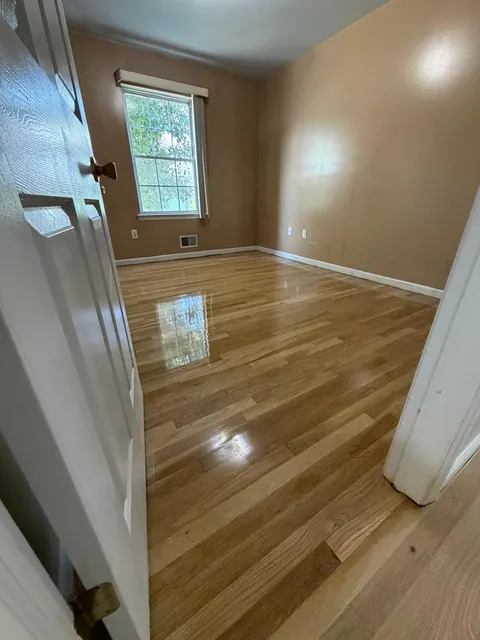 Refinished red oak floor seen through a bedroom doorway