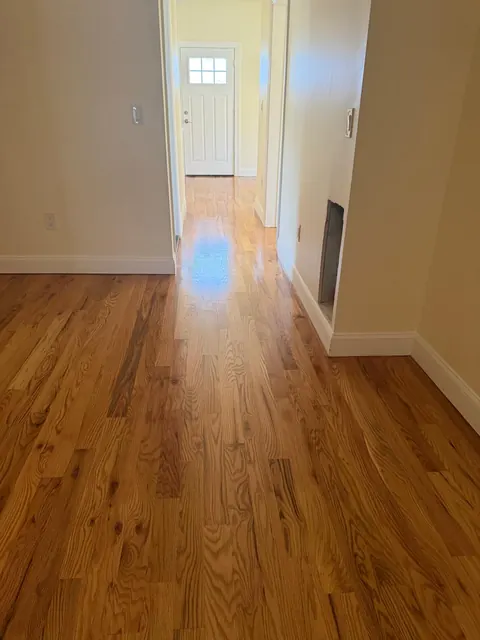 Hallway toward the front door with a refinished oak floor