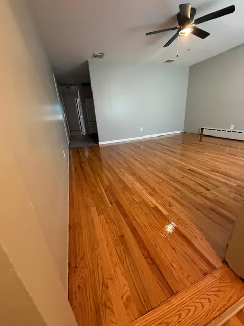Living room with ceiling fan and a refinished oak floor