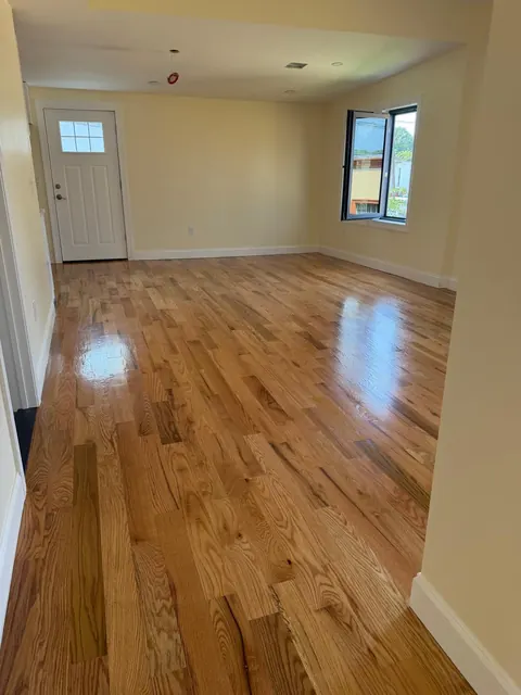 Living room with front door and a refinished oak floor, satin sheen