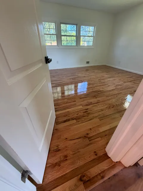 Bedroom seen through the doorway, refinished oak with varied grain