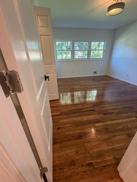 Room with a refinished oak floor and a large window