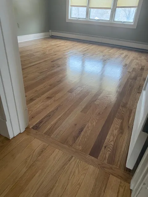 Refinished oak floor with a contrasting threshold between rooms