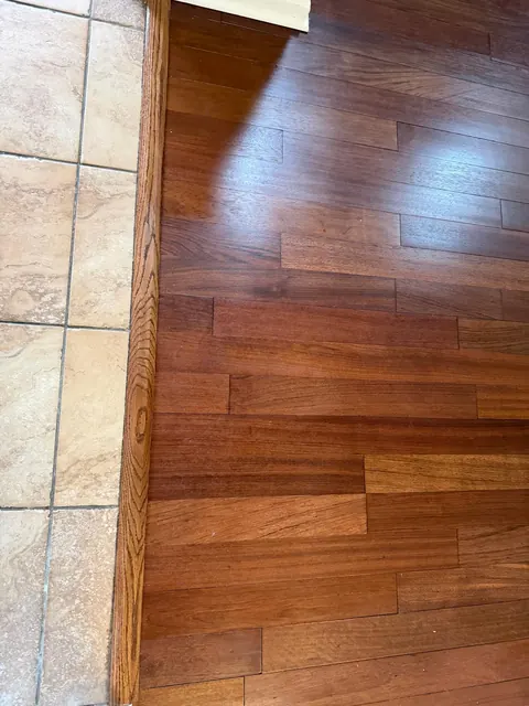 Dark stained hardwood meeting a tile floor at a doorway