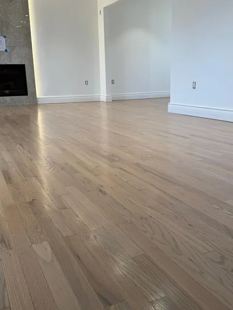 Open living room with fireplace and a natural finish white oak floor